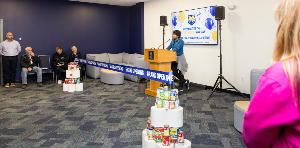 A student talking behind a podium with a big blue ribbon sitting in front of it