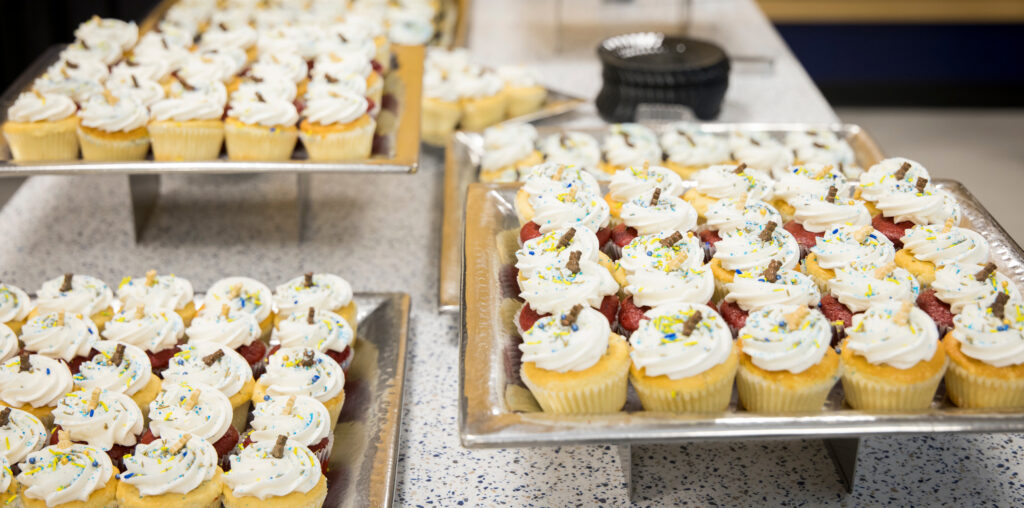 Three cookie sheets filled with cup cakes