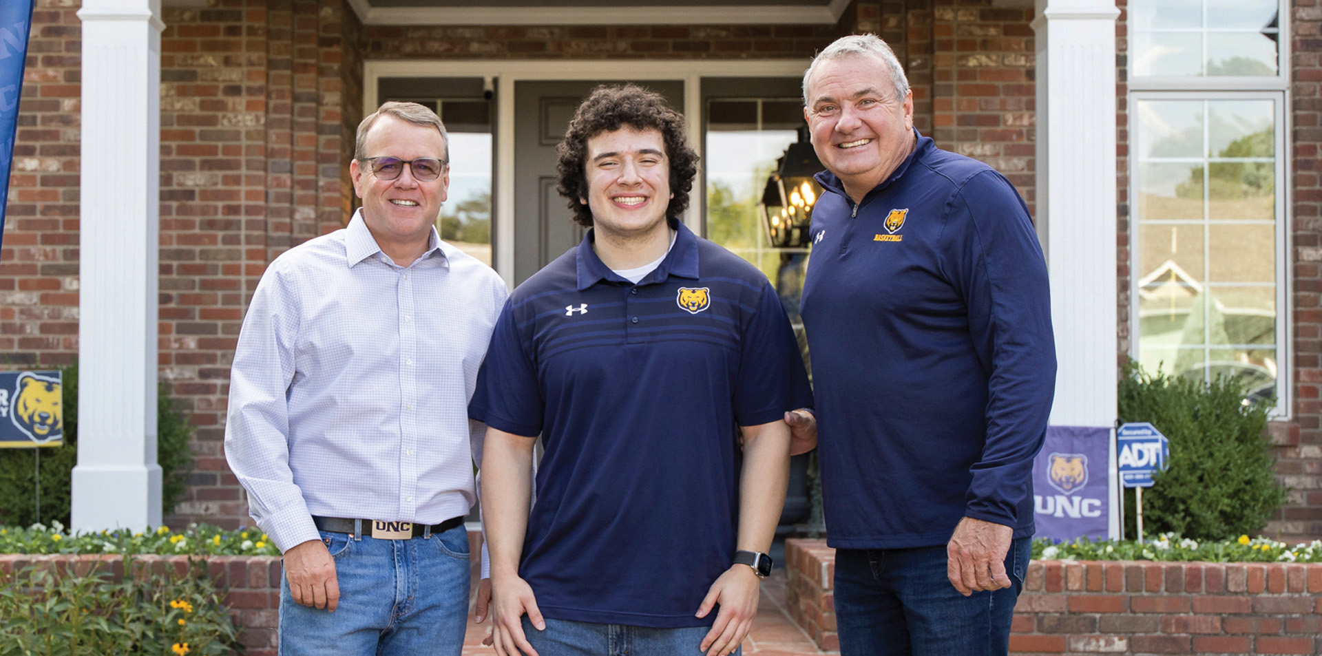 Daniel Garza standing in between two gentleman wearing a UNC shirt