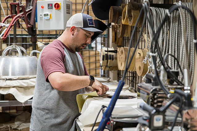 A worker working on creating a hat