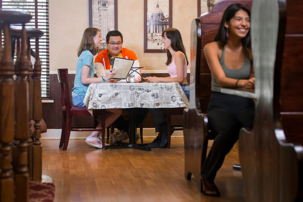 People sitting at dining tables inside a restaurant