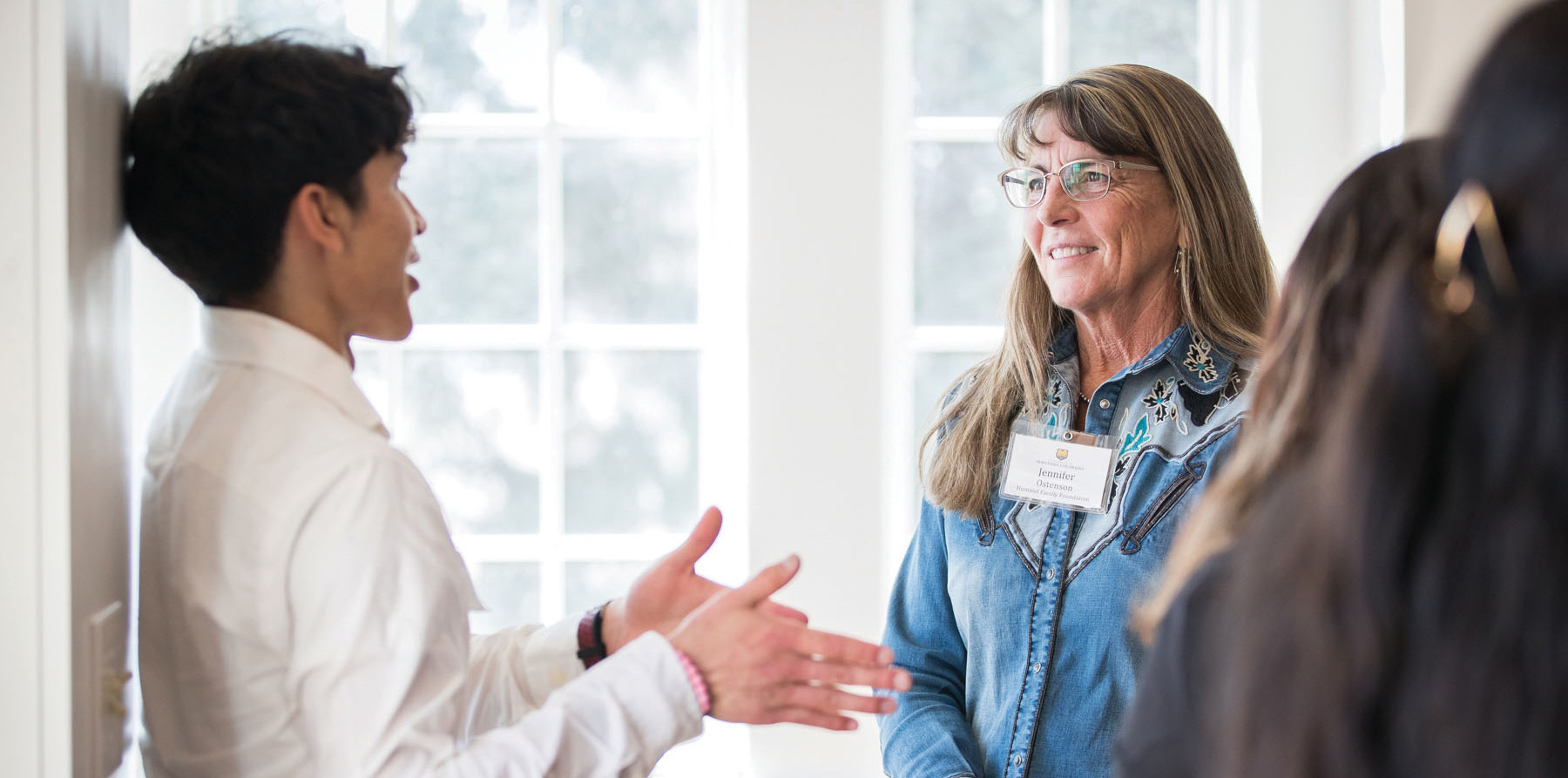 Jennifer Ostenson smiling while talking to a student
