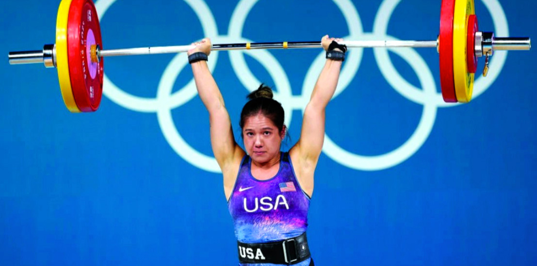 Jordan Delacruz lifting up her weights wearing a USA uniform
