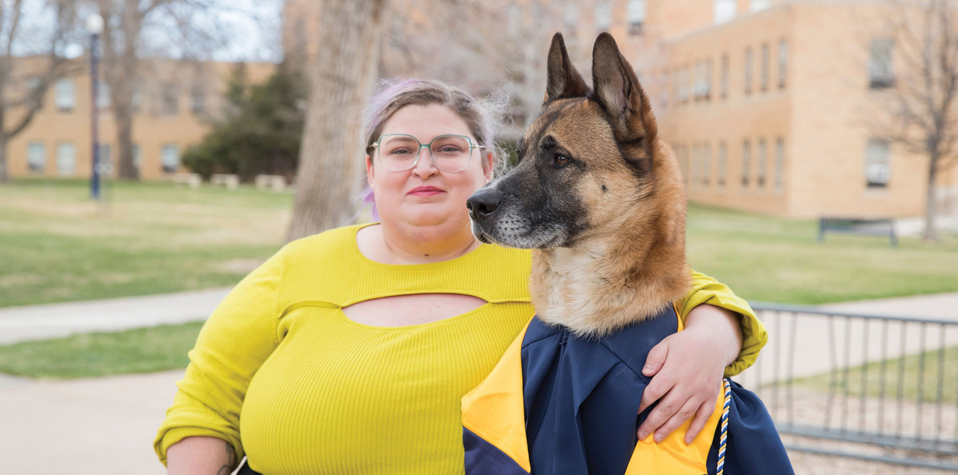 Kayla Minton and her dog Banjo sitting together outside on campus