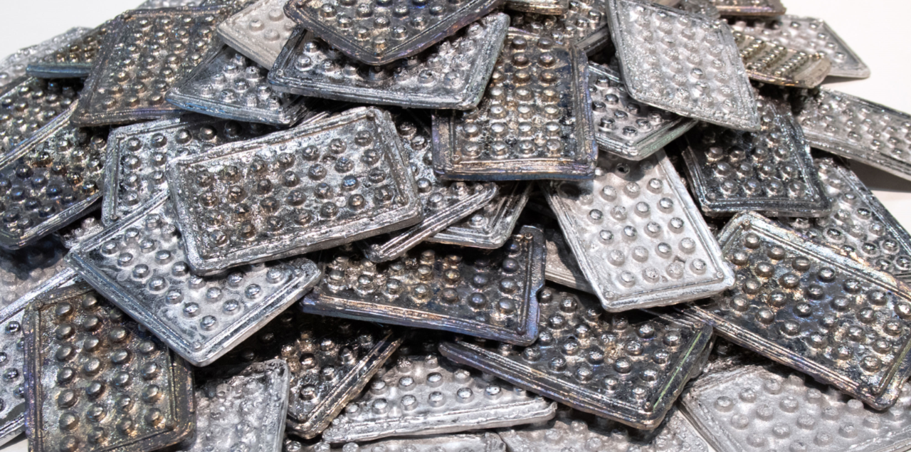 A sculpture made of a pile of metal sheets shaped to look like pill containers.