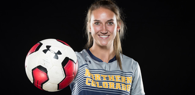 Lexi Pulley holding a soccer ball and smiling