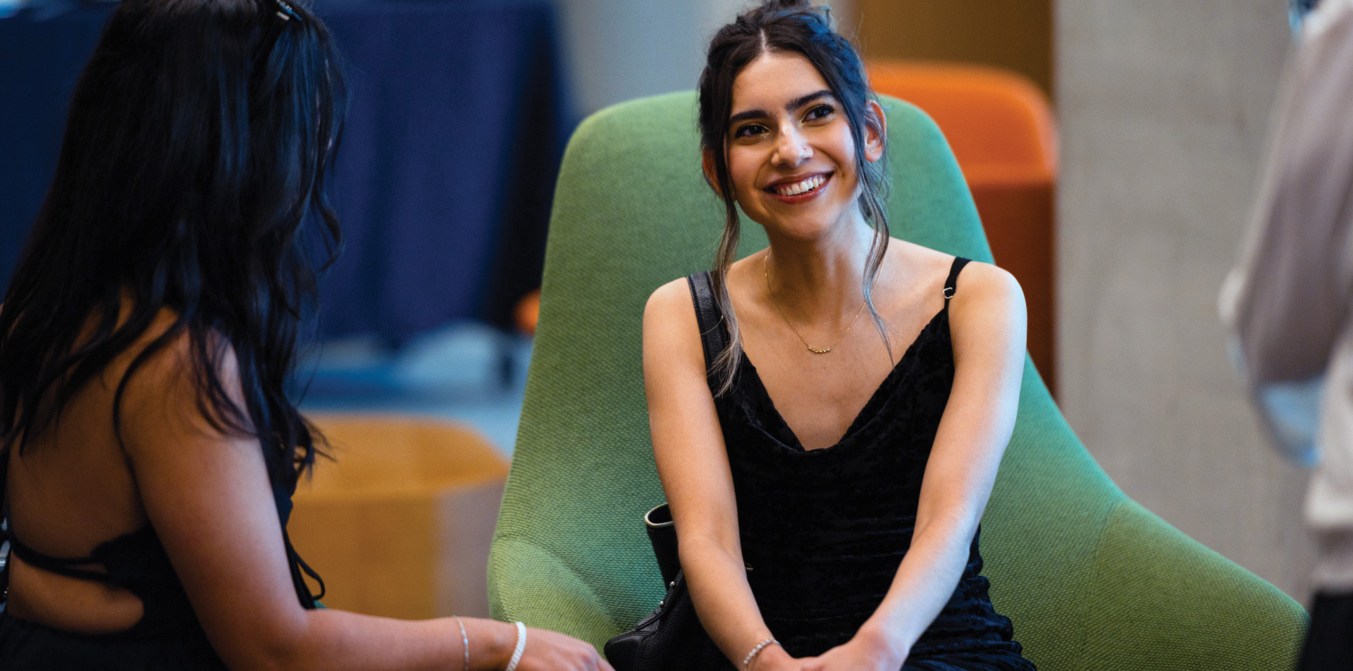 Liz Baylon Trejo sitting in a green armchair and smiling