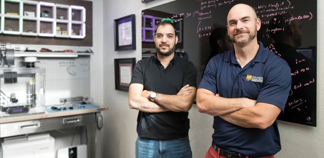 Moe Manshad standing next to Daniel Brannon with their arms crossed