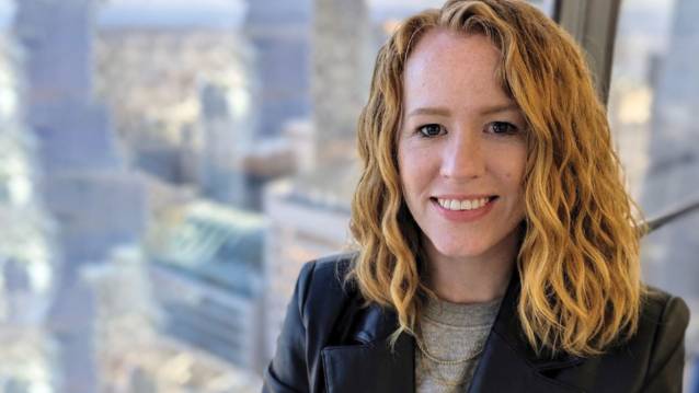 UNC student Nikki Cooper smiling at the camera in front of a city skyline.