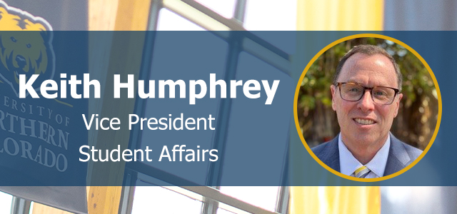 Keith Humphrey smiling and facing front on a UNC background logo.