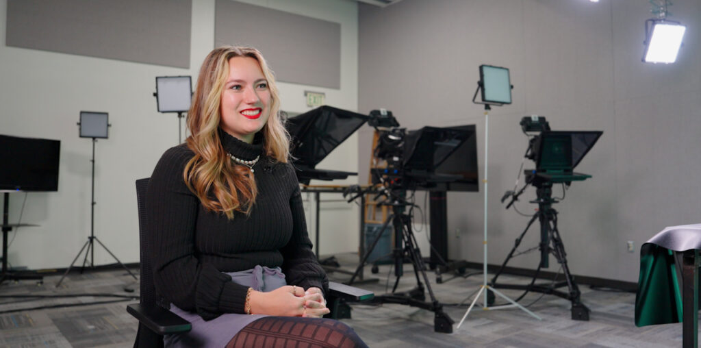 Sophia Tavanello sitting and smiling toward the right