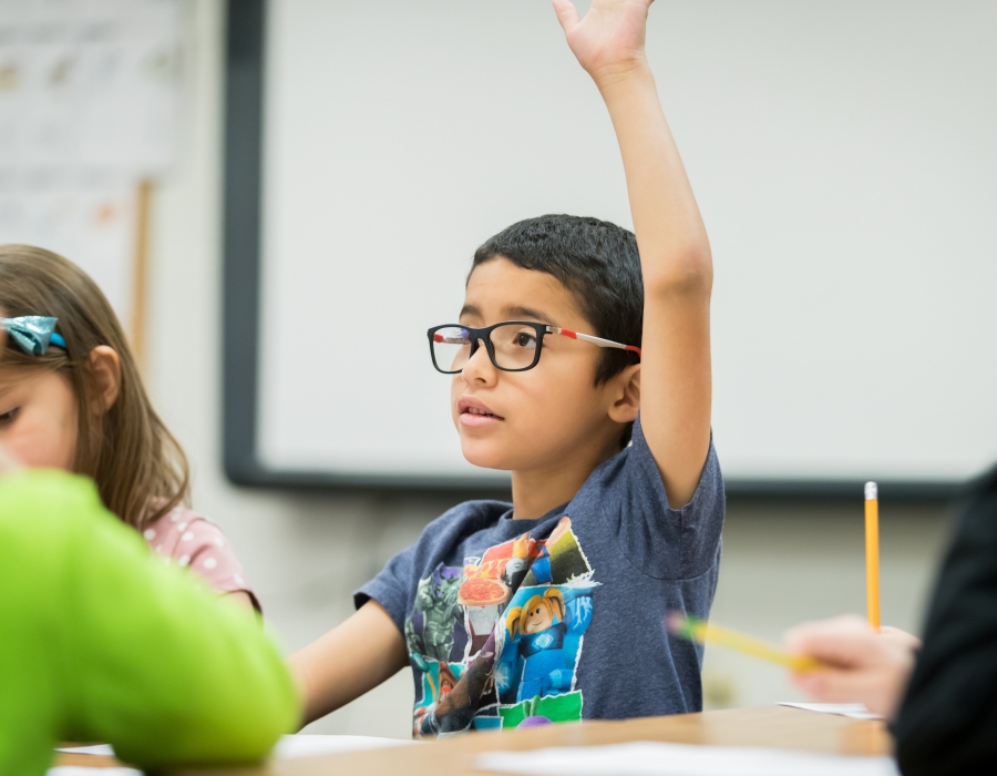 Early Childhood Education student raising his hand in the classroom