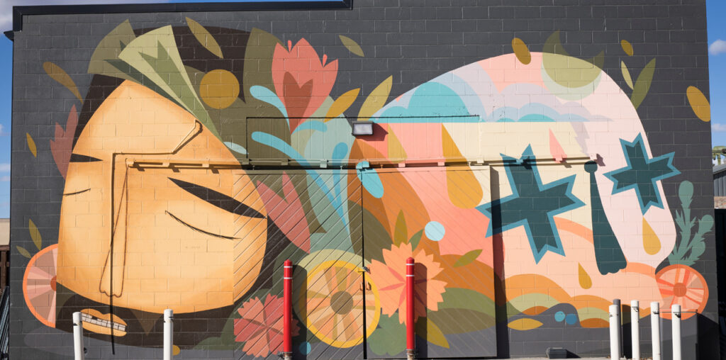 A stylized mural of a skull and a man with a beard.