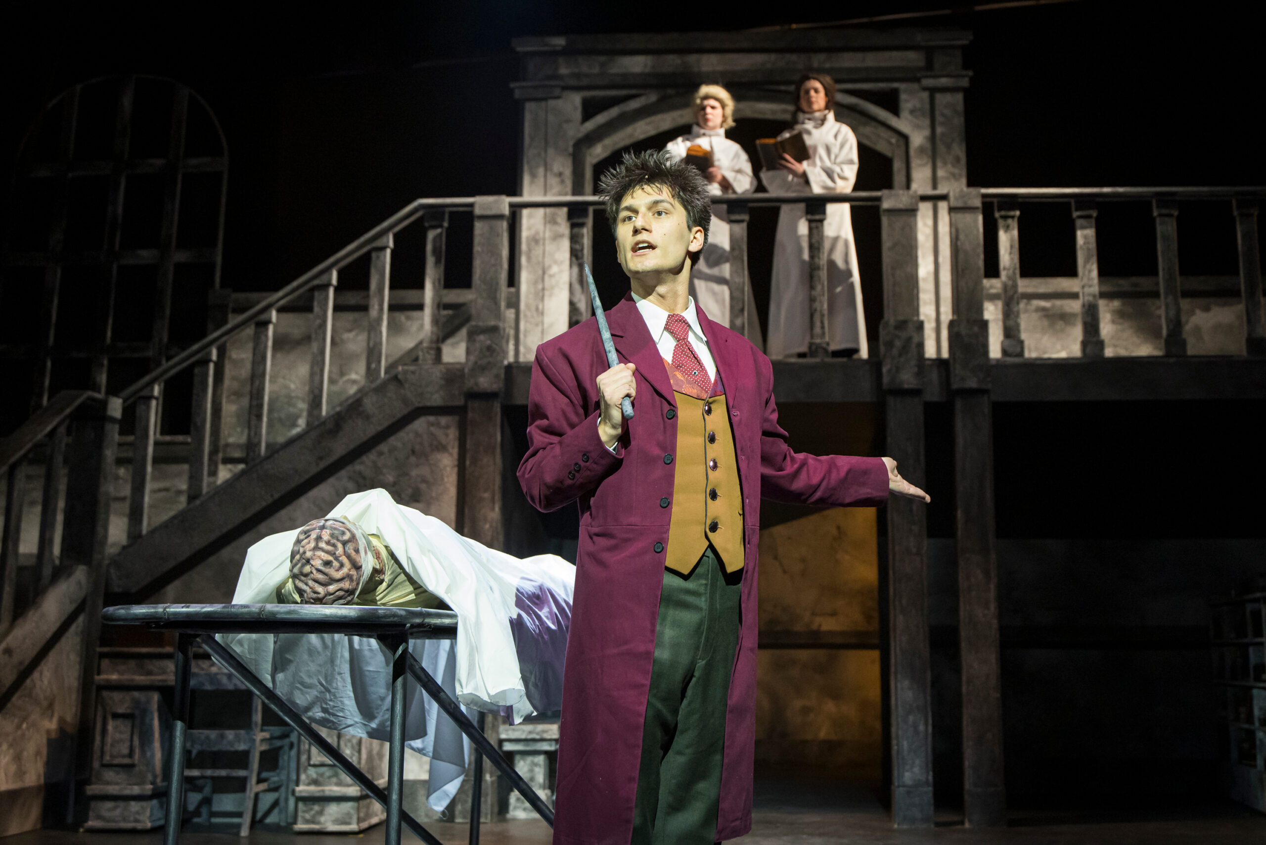 A character on stage in a suit with a fake body in Dr. Jekyll and Mr. Hyde.