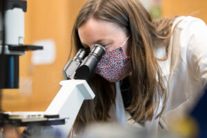 Student looking through microscope in lab