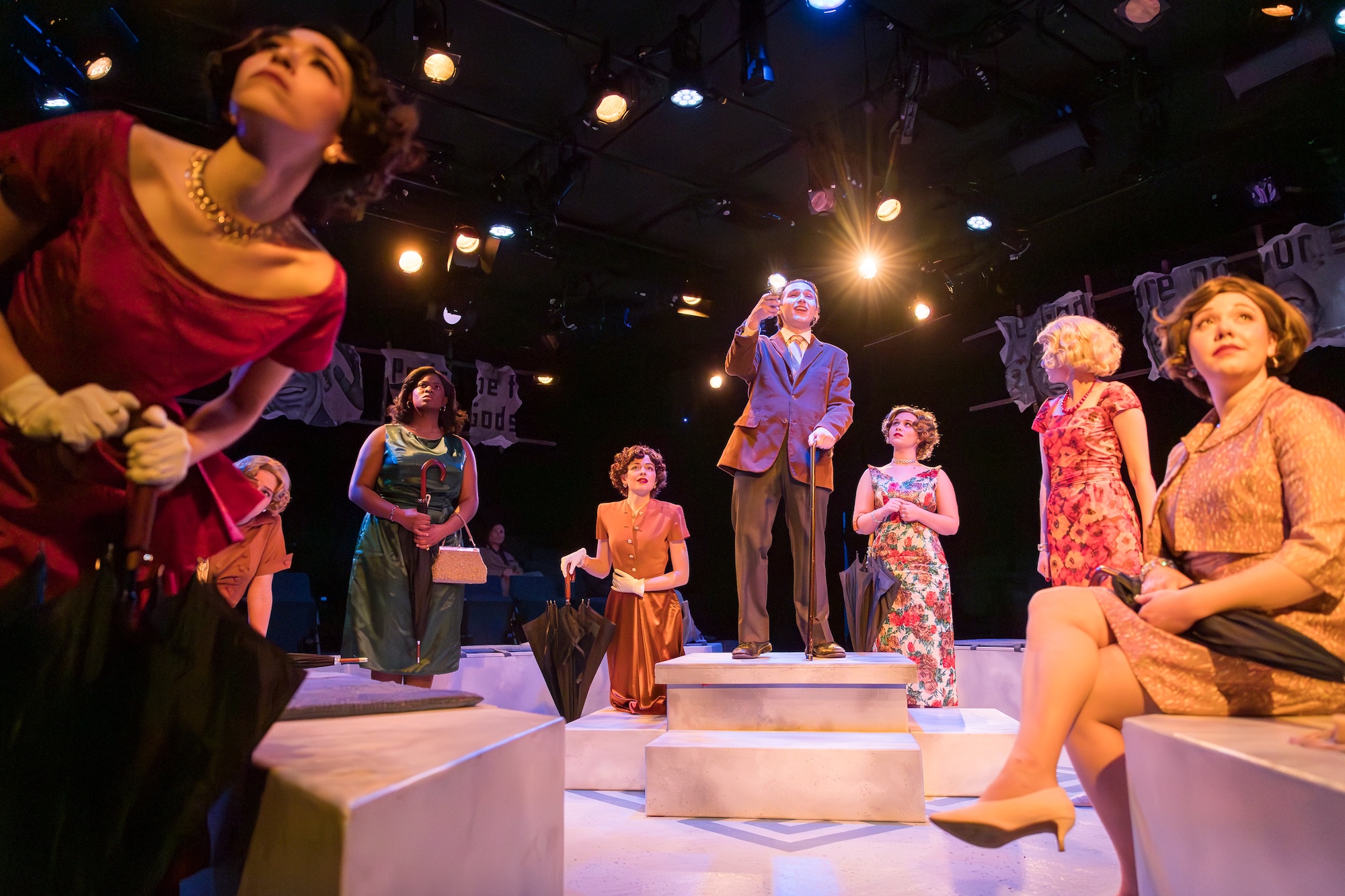 Several characters looking to a central point in This Restless House play.