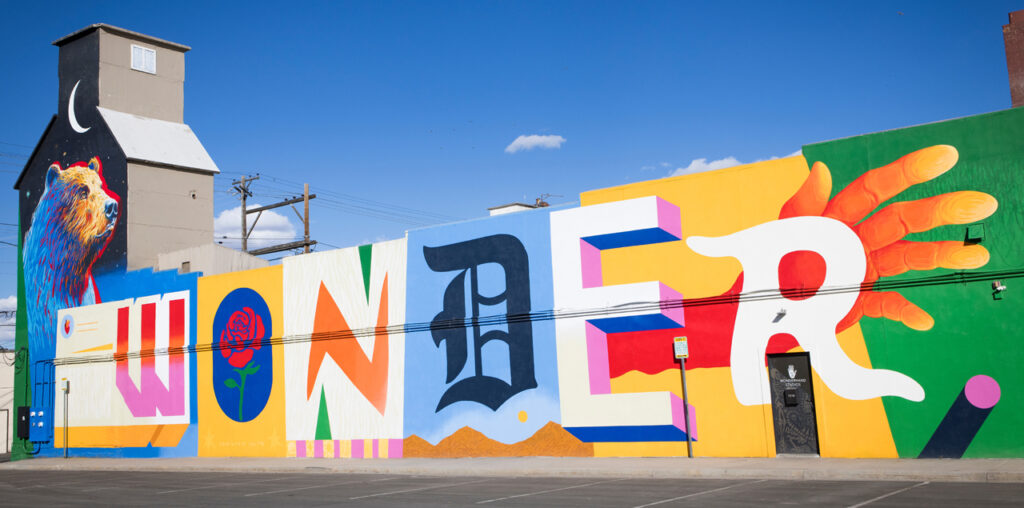 A colorful mural of the word "wonder" on the side of a building.