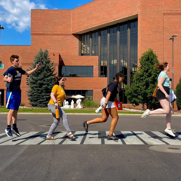 Four Honors Students crossing sidewalk while on Honors Retreat emulating Beatles walk