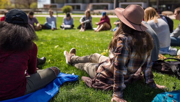 Students sitting on grass in a circle