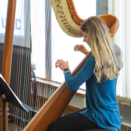 Honors student performing on Harp