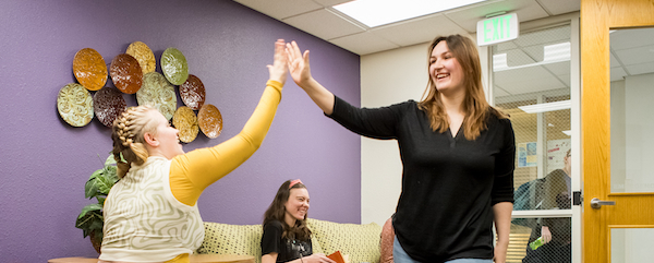 Two students in U-Engage Lounge high fiving.