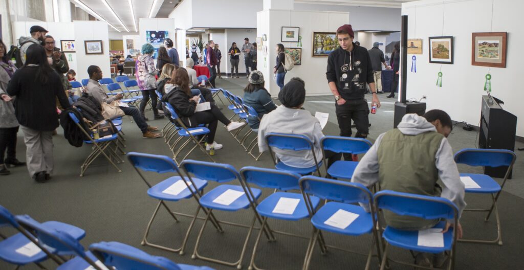 Attendees mingling at the reception for an exhibit in the Mari Michener Gallery in Michener Library