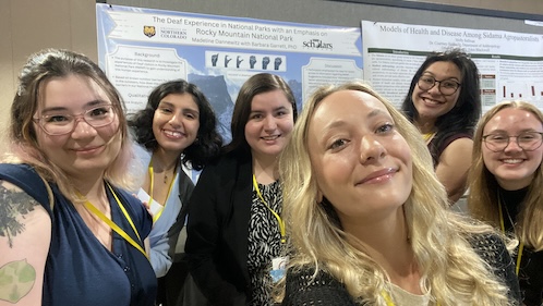 Group of students posing in front of a poster at the 2024 National Conference of Undergraduate Research