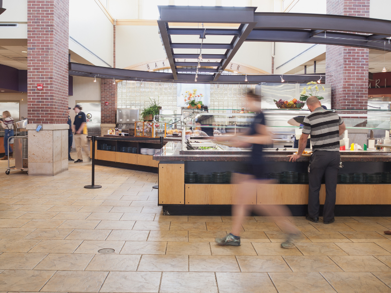 A long exposure photograph of a student walking in Holmes Dining Hall