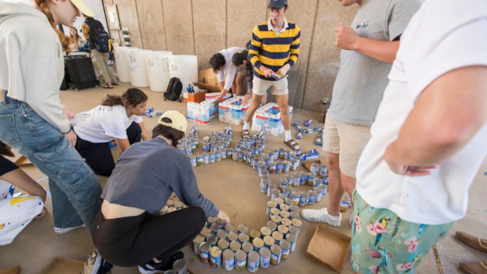 Students collect canned goods at a food drive.