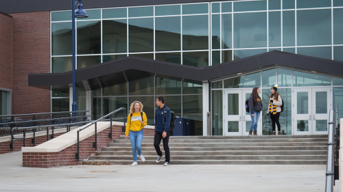 Students chat as they walk outside of the Campus Commons.