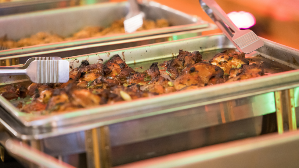 A pork dish sits in a chafing dish