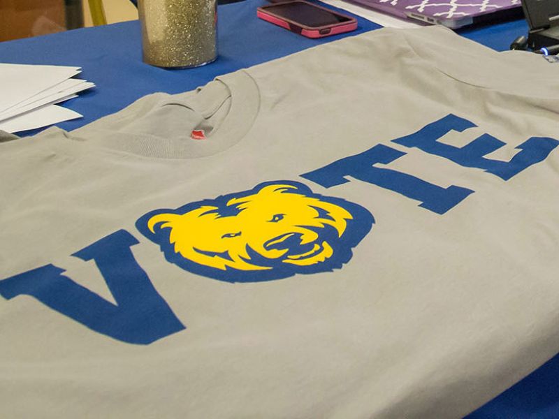 A graphic tee with V.O.T.E written across the chest. The 