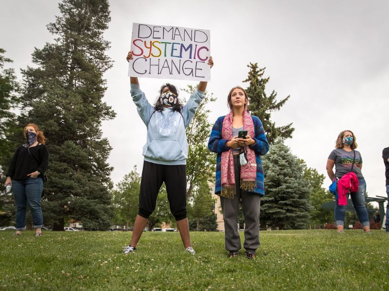Students stand on campus with signs during a protest