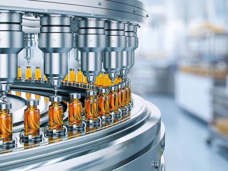 Drug manufacturing process showing conveyor with medication bottles at a pharmaceutical plant.