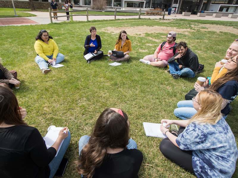 Circle of students on the grass during an honors course.