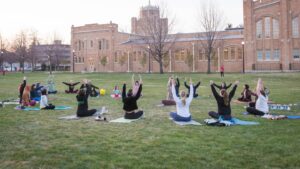 Students doing yoga in a campus quad