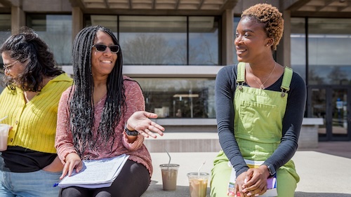 Two female students of color talking outside