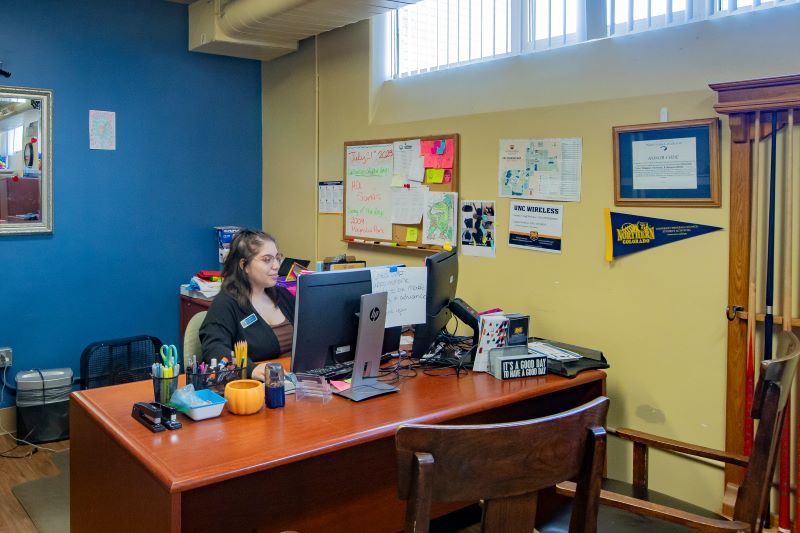 Person sitting behind desk with smile ready to help you