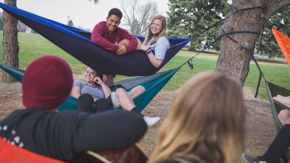 Students enjoy a conversation from hammocks