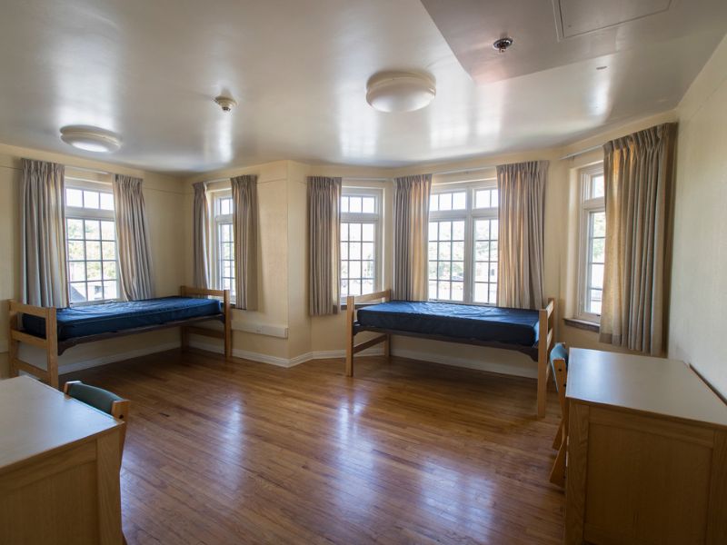 An interior photo of a Lujan room featuring beautiful, bright bay windows