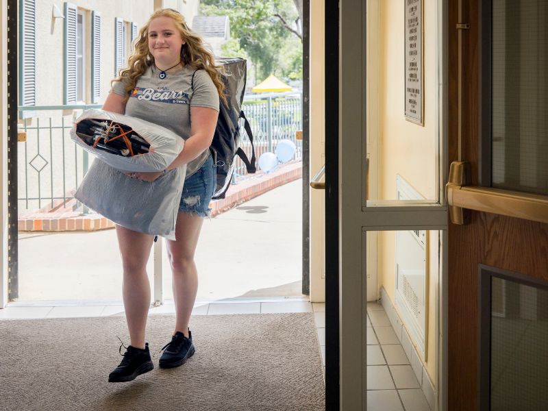 A student moving in with a pillow