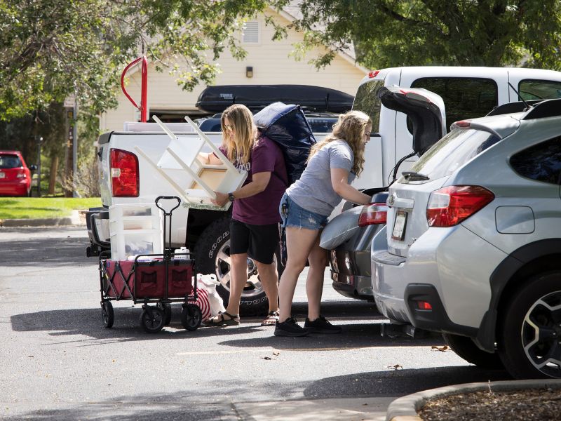 Students and parents unpacking a car on move-in day