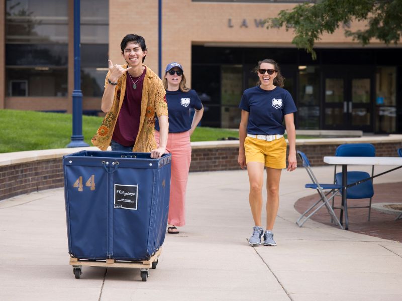 A student pushes a cart during move-in