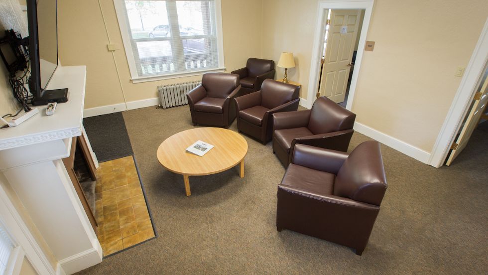 Trotter house living room features five leather chairs arranged around a round coffee table
