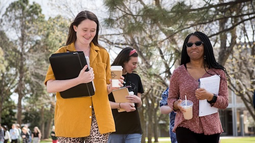 Women students walking outside on campus