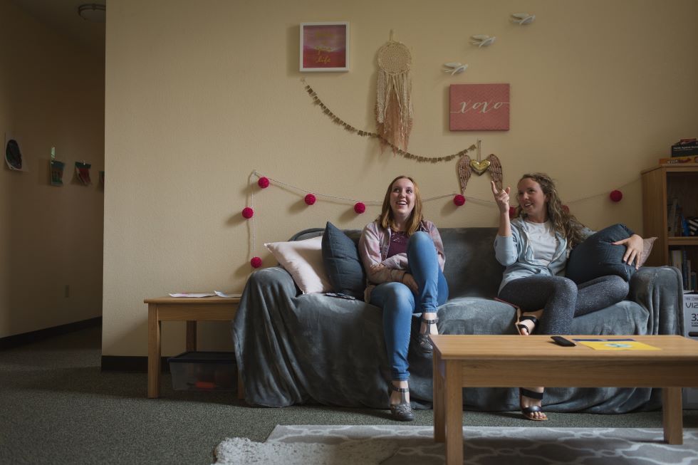 two Students Lounging On Couch
