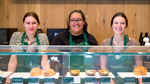 Three female students working at Starbucks on campus