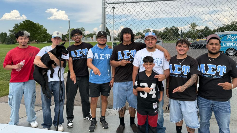 Members of a fraternity pose for a group photo in coordinating shirts