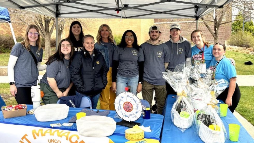 Students in a club pose for a group photo during an outdoor event