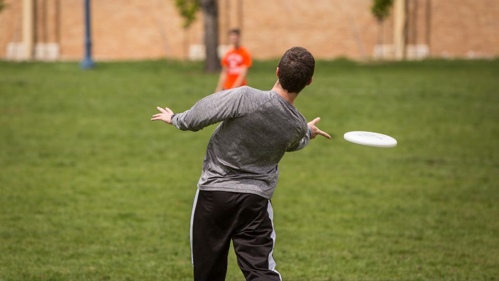 Two students play frisbee